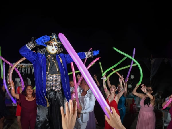 Animación nocturna en evento con personaje disfrazado y globos de colores entre los invitados