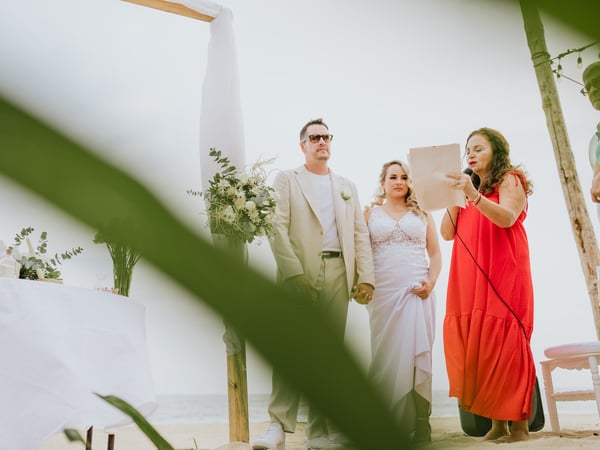 Ceremonia de boda en terraza con palapa y vegetación tropical junto al mar