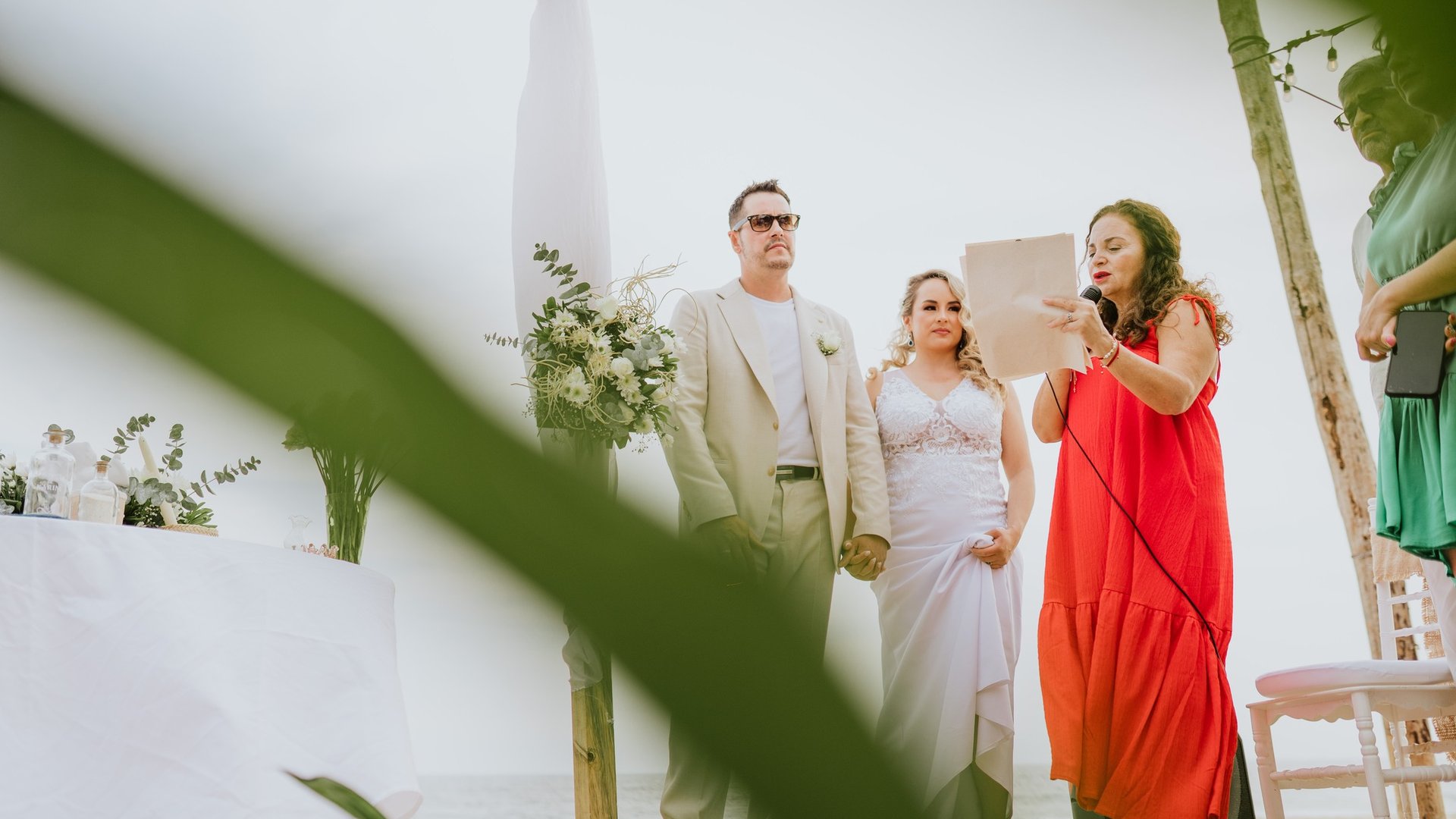 Ceremonia de boda en terraza con palapa y vegetación tropical junto al mar