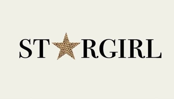 Decorative text graphic featuring 'STAR GIRL' in bold black letters with gold star accents on a light beige background.