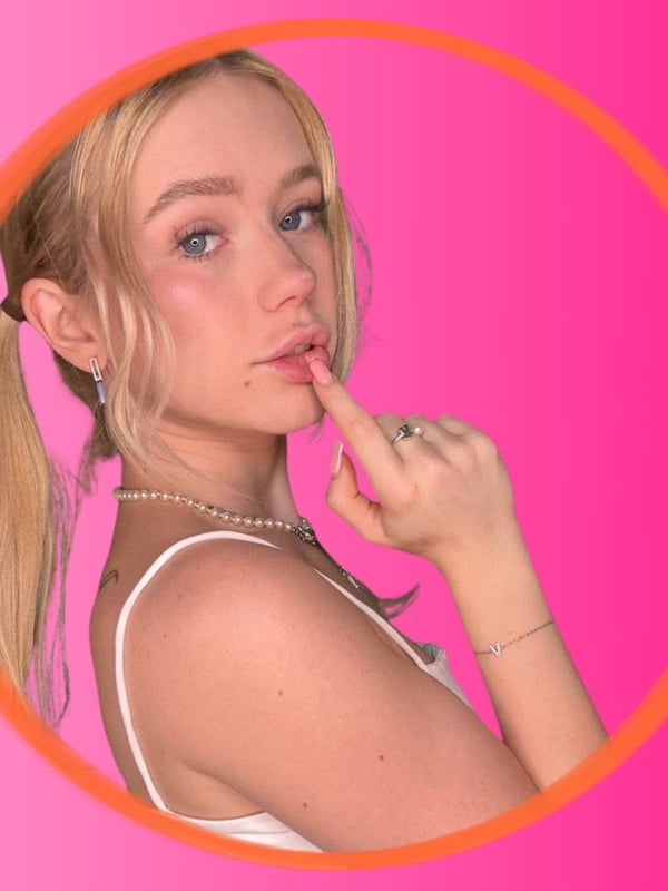Close-up of a young blonde woman with pigtails, wearing a white top, framed in a pink circle against a gradient background, making a playful gesture.