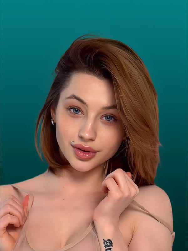 Close-up portrait of a young woman with shoulder-length brown hair and blue eyes, smiling softly against a teal background.