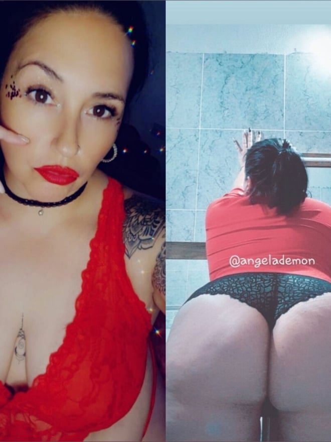 A woman with tattoos and facial glitter posing seductively in red lingerie against a bathroom tiled background, with a backside view.