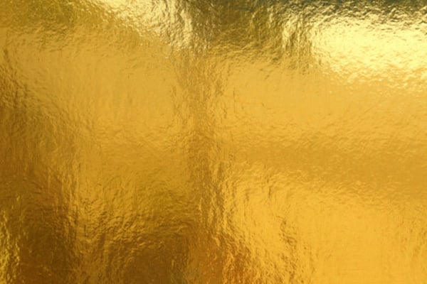 Shiny gold textured background with reflective metallic surface.