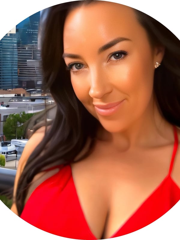 A smiling woman with brunette hair wearing a red swimsuit top, posing against an urban skyline with buildings and trees in the background.