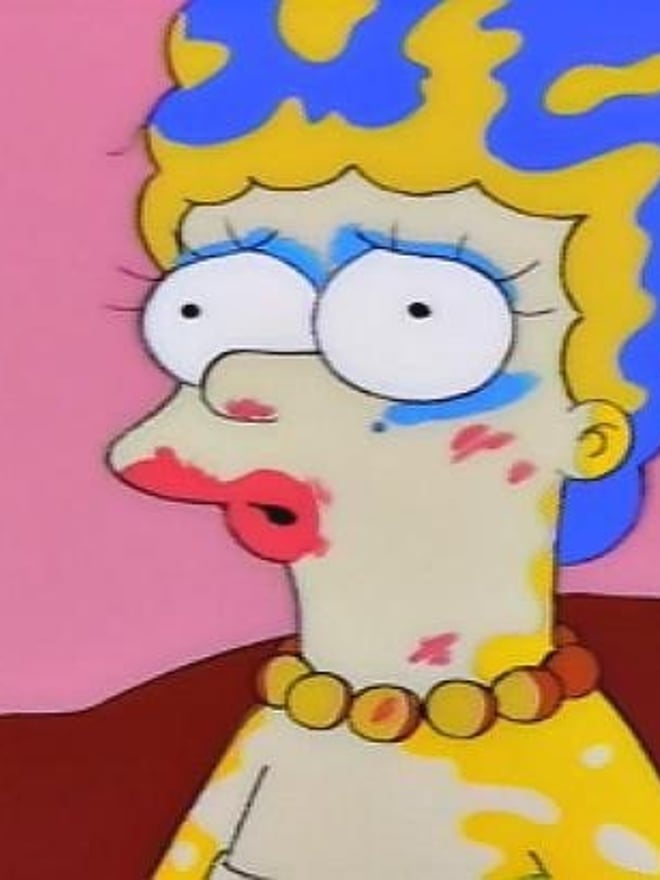 Cartoonish character resembling Marge Simpson with exaggerated blue hair, heavy makeup, and colorful necklace in a pink room setting.