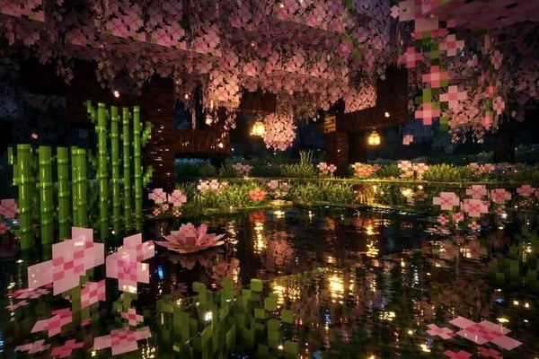 A fantastical Minecraft scene featuring pink cherry blossoms, bamboo, lanterns, and a reflective water garden in a dimly lit cave.