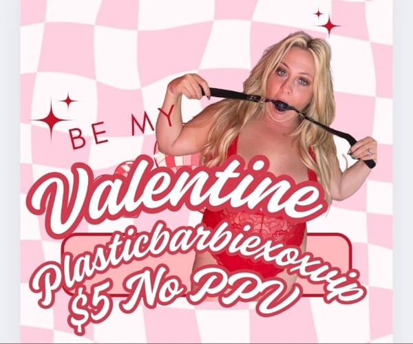 A blonde woman in a red lace outfit posing playfully with a prop against a pink checkered background with Valentine's Day text and decorations.