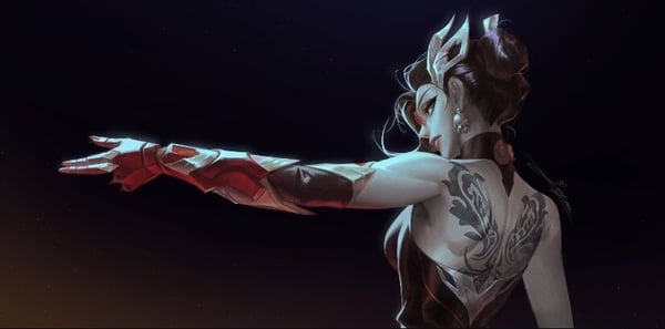 A person in an elaborate fantasy costume with arm guards and back tattoo, posing dynamically in a dark setting.
