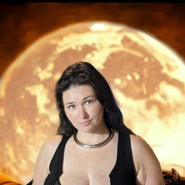 A woman with long dark hair wearing a black sleeveless top and choker necklace, posing confidently in front of a large glowing full moon with a warm orange background.