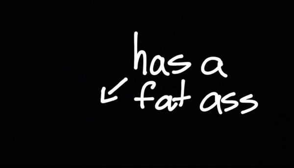 Black background with white handwritten text stating 'has a fat ass'.