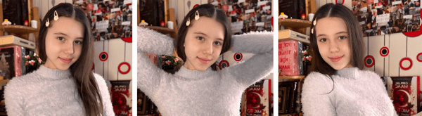 Young woman with long dark hair and hair clips smiling playfully in a cozy room with holiday decorations and toys in the background.