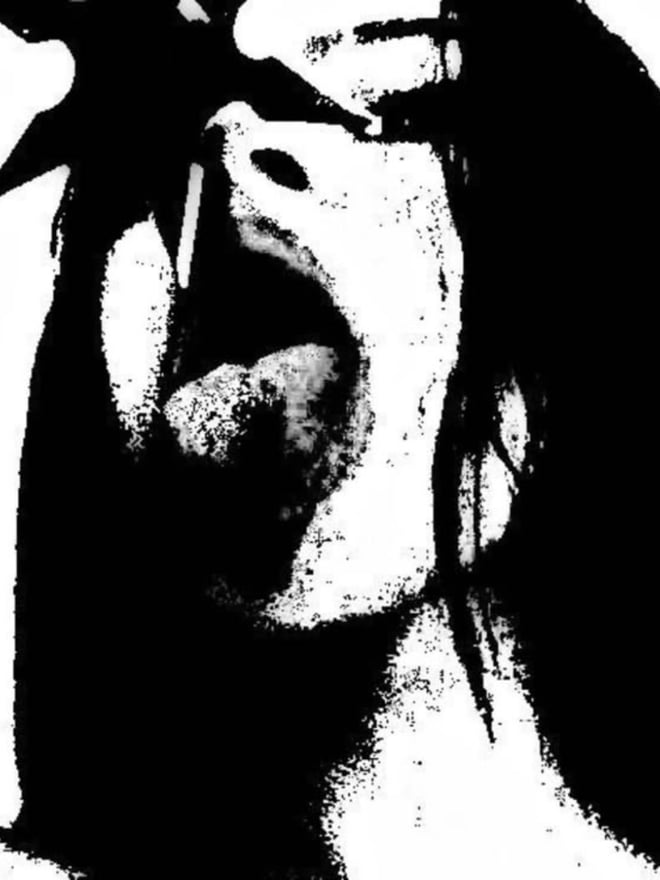 Black and white close-up of a woman with long hair making a playful facial expression.