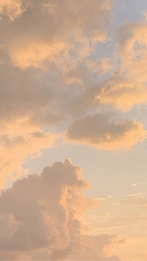 A pastel sunset sky filled with layered clouds.