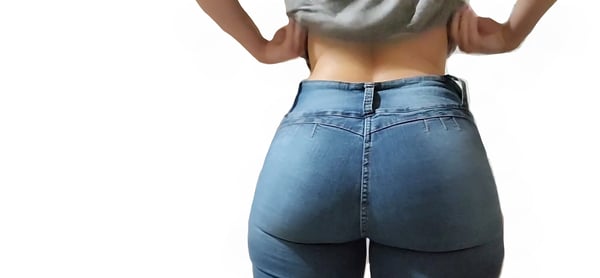 A person standing with back turned, wearing tight blue jeans and a gray top, hands on hips against a plain background.