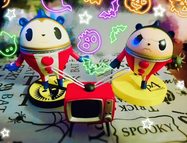 Collection of colorful anime-style figurines posed on a spooky Halloween-themed background with neon effects and bats.