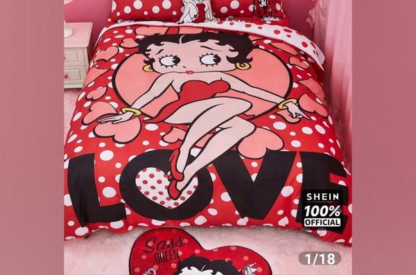 Colorful bedsheets featuring a cartoon character in a playful pose with heart and polka dot patterns on a pink background.
