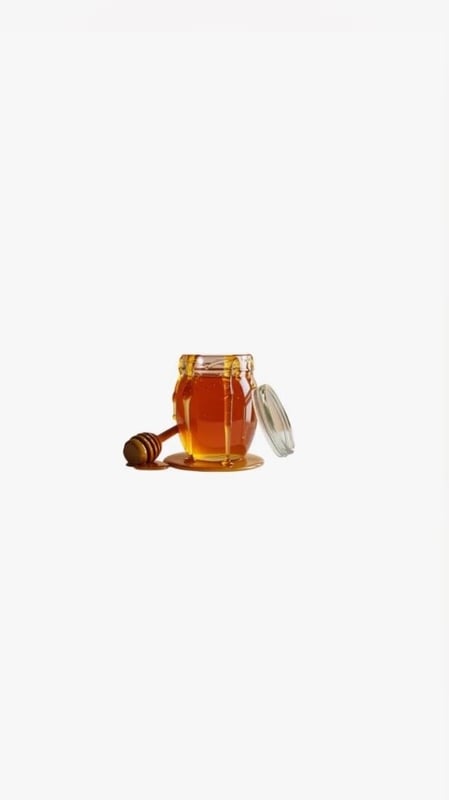 A jar of honey with a wooden dipper on a surface.