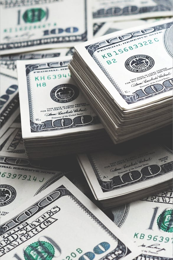 Stacks of U.S. hundred-dollar bills arranged in a pile.
