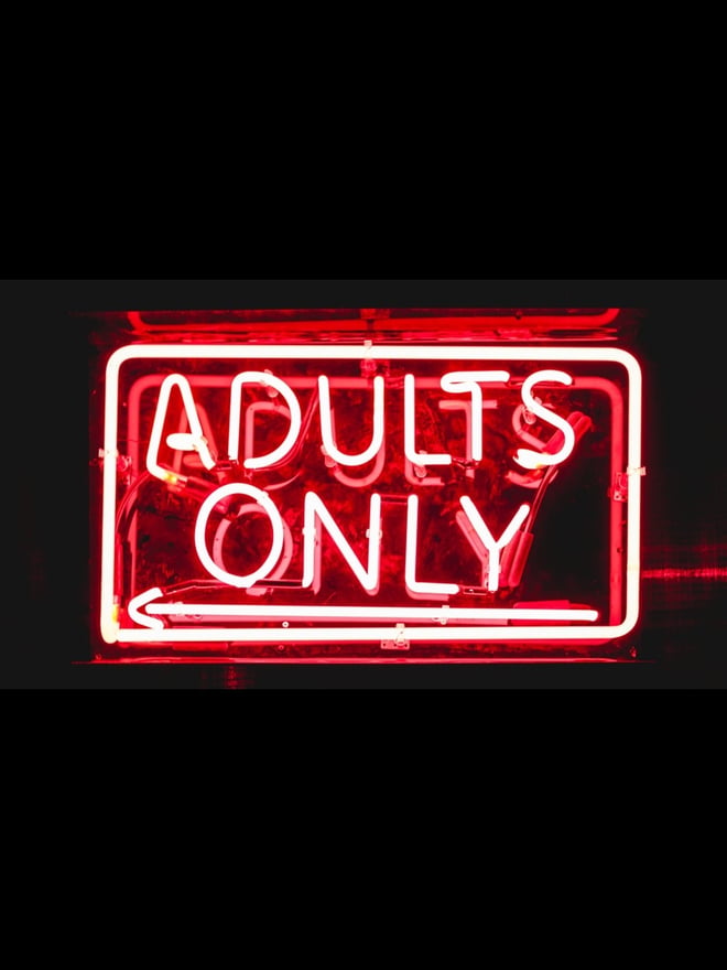 A neon red 'Adults Only' sign glowing against a black background.