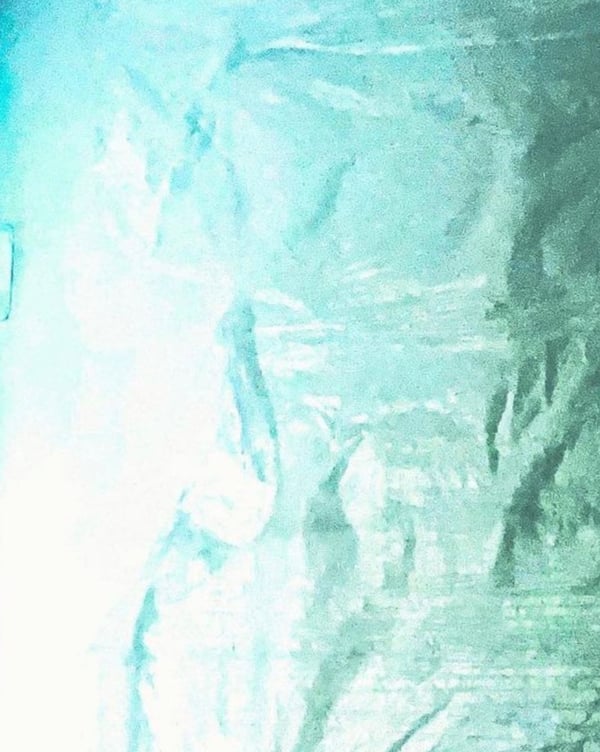Abstract teal and green textured background with shiny metallic effects.