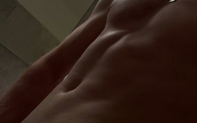 Close-up of a muscular torso with defined abs and light chest hair.