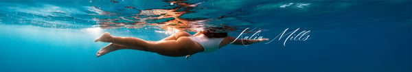 A young woman swimming underwater in a swimsuit with sunlight filtering through the water, her name overlaid on the image.
