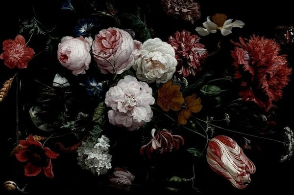 A close-up artistic arrangement of various colorful flowers, including white and pink roses, against a dark background.