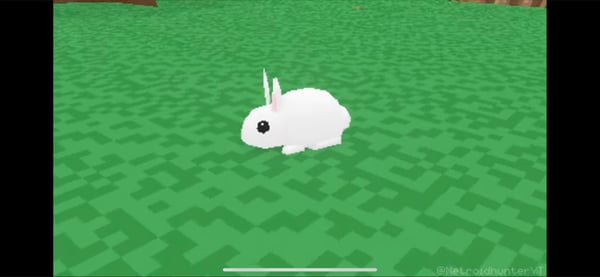 A cute white bunny with long ears standing on a vibrant green checkered field.