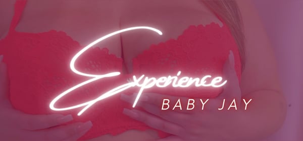 Neon text reading 'Experience Baby Jay' overlaid on a close-up of a person in red lace attire.