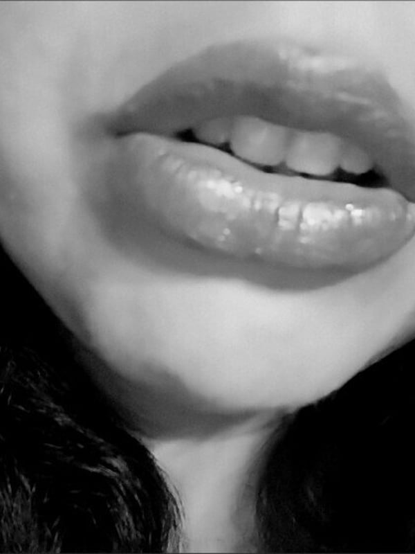 Black and white close-up portrait of a woman with dark hair, full lips pursed seductively.