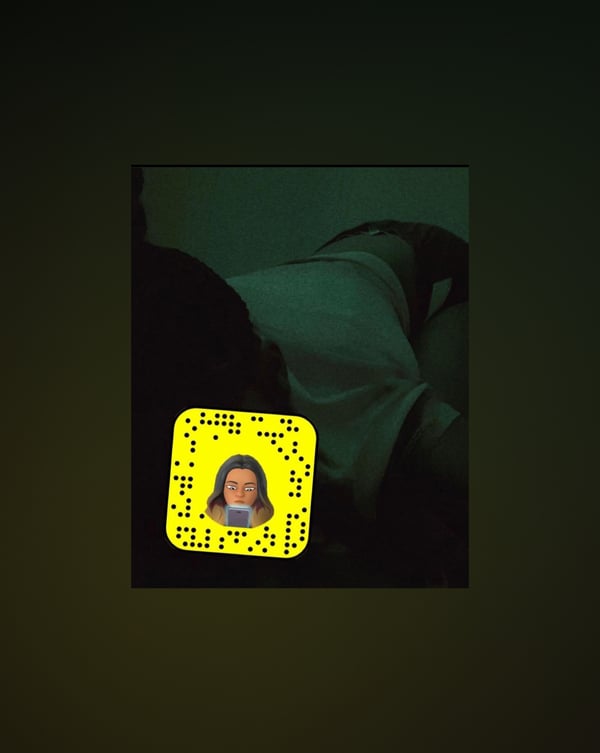 A person lying on a surface in casual clothing with a Snapchat QR code overlay in the corner.