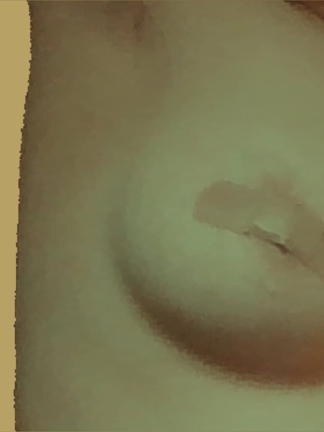 Close-up image of a person's upper body with visible chest contours, set against a warm beige background.