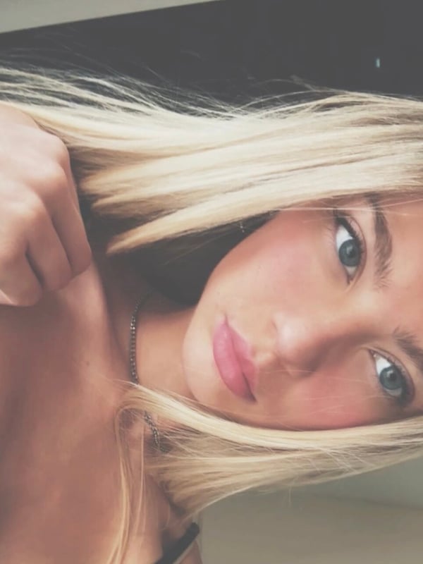 Close-up portrait of a young woman with long blonde hair and blue eyes.