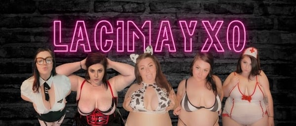 Group of five women in costumes posing playfully in front of a neon sign on a dark brick background.