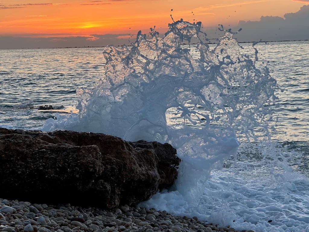 Waves Crashing Against Rocks at Sunset