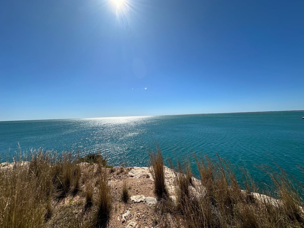 Sunlit Cliff Over Turquoise Sea