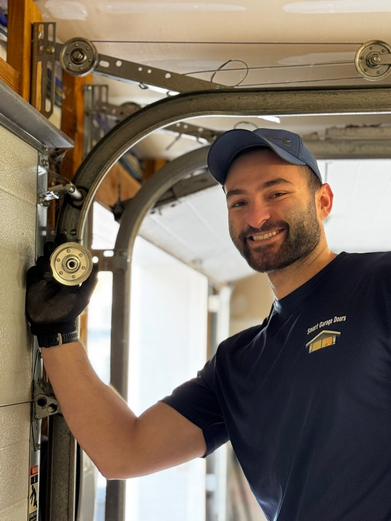Ben, Smart Garage Doors technician, smiling while working on cable and roller system