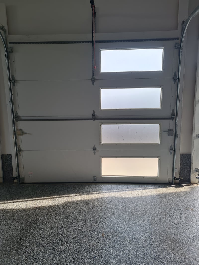 Interior view of a newly installed contemporary glass-panel garage door