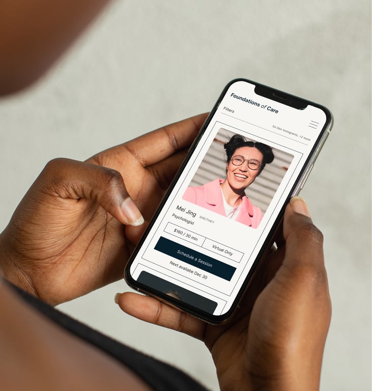 Hands holding a phone showing Foundation of Care's therapist directory