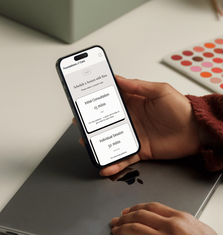 Hands holding a phone showing Foundations of Care's therapist dashboard