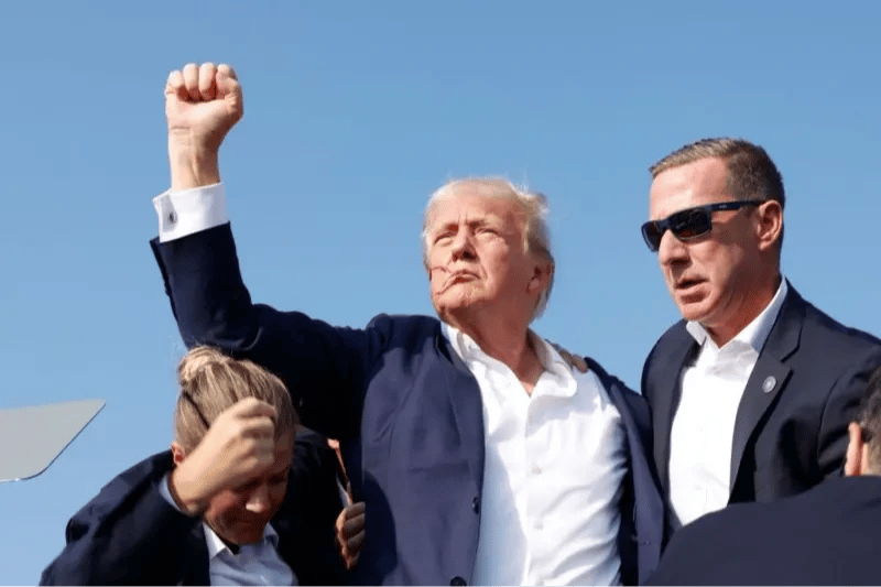 Donal Trump, podyumdan götürülmeden önce kalabalığı yumruğunu kaldırarak selamladı. 