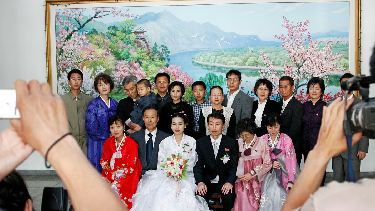 Kuzey Koreli gelin ve damat (ortada), 15 Mayıs 2012'de Kuzey Kore'nin Pyongyang kentinde bir düğün partisi düzenlemek üzere Kyonghung evlilik restoranında aileleriyle birlikte fotoğraflanıyor. Fotoğraf: AP / Kim Kwang Hyon