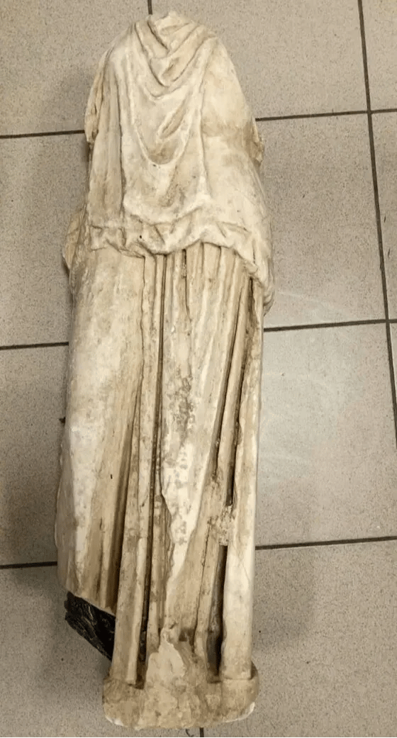Yunan Polisi tarafından yayımlanan bu fotoğrafta, Selanik'teki bir sokakta "çöp kutularının yanında siyah plastik bir poşet içinde bir vatandaş tarafından görülen" antik bir heykel görülüyor. Fotoğraf: AFP/Yunan Polisi