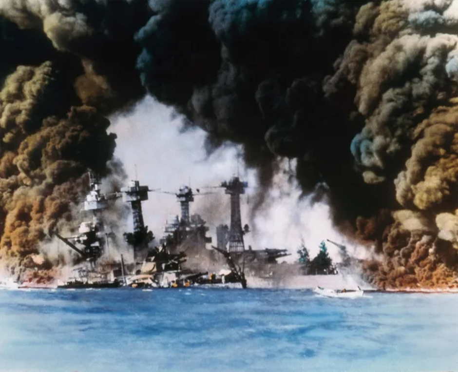 Saldırı sırasında ABD Pasifik Filosunun hasar görmüş savaş gemilerinden dumanlar yükseliyor.