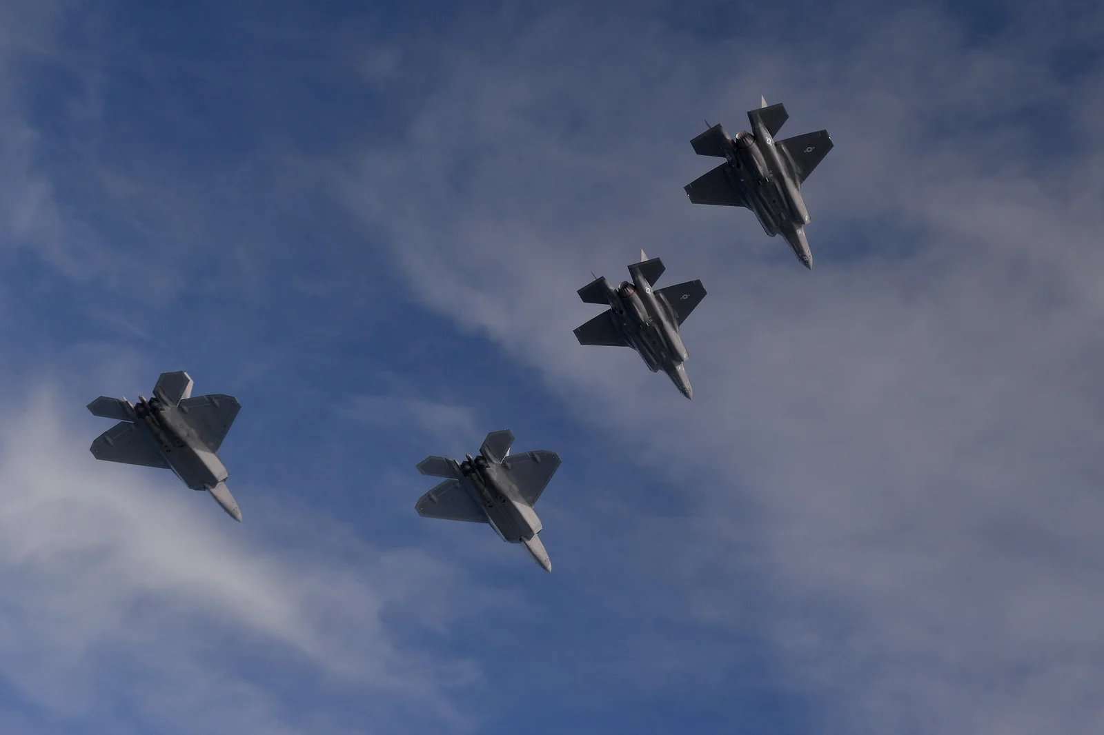 F-22 Raptors and F-35A Lightning IIs fly in formation over the Eglin Range, Florida, Nov. 5, 2014. U.S. Air Force photo by Master Sgt. Shane Cuomo (public domain)