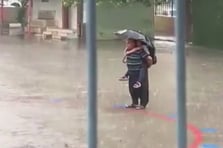 Yağmur altında dede torunu İstiklal Marşı okudu