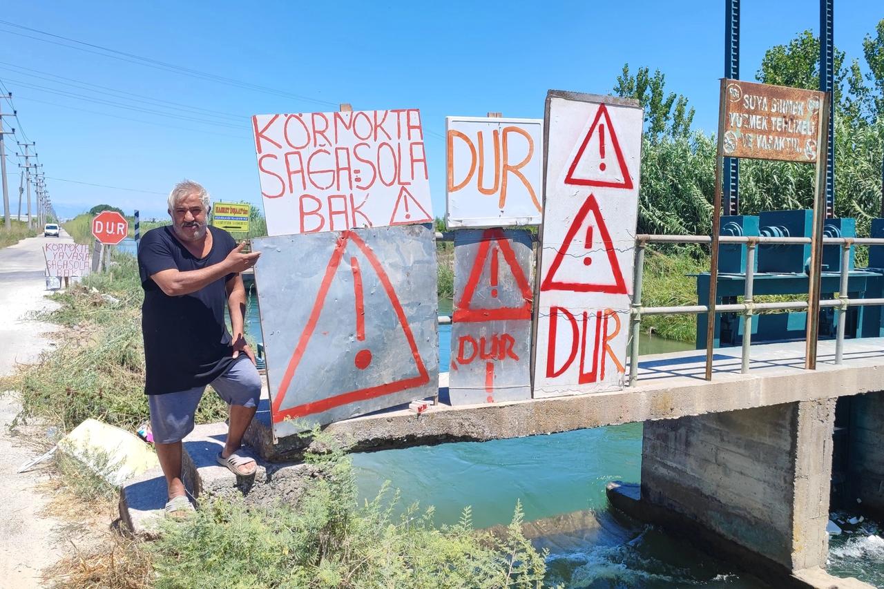 Sürekli kazaların yaşandığı yola kendi imkanlarıyla uyarı levhası yaptı
