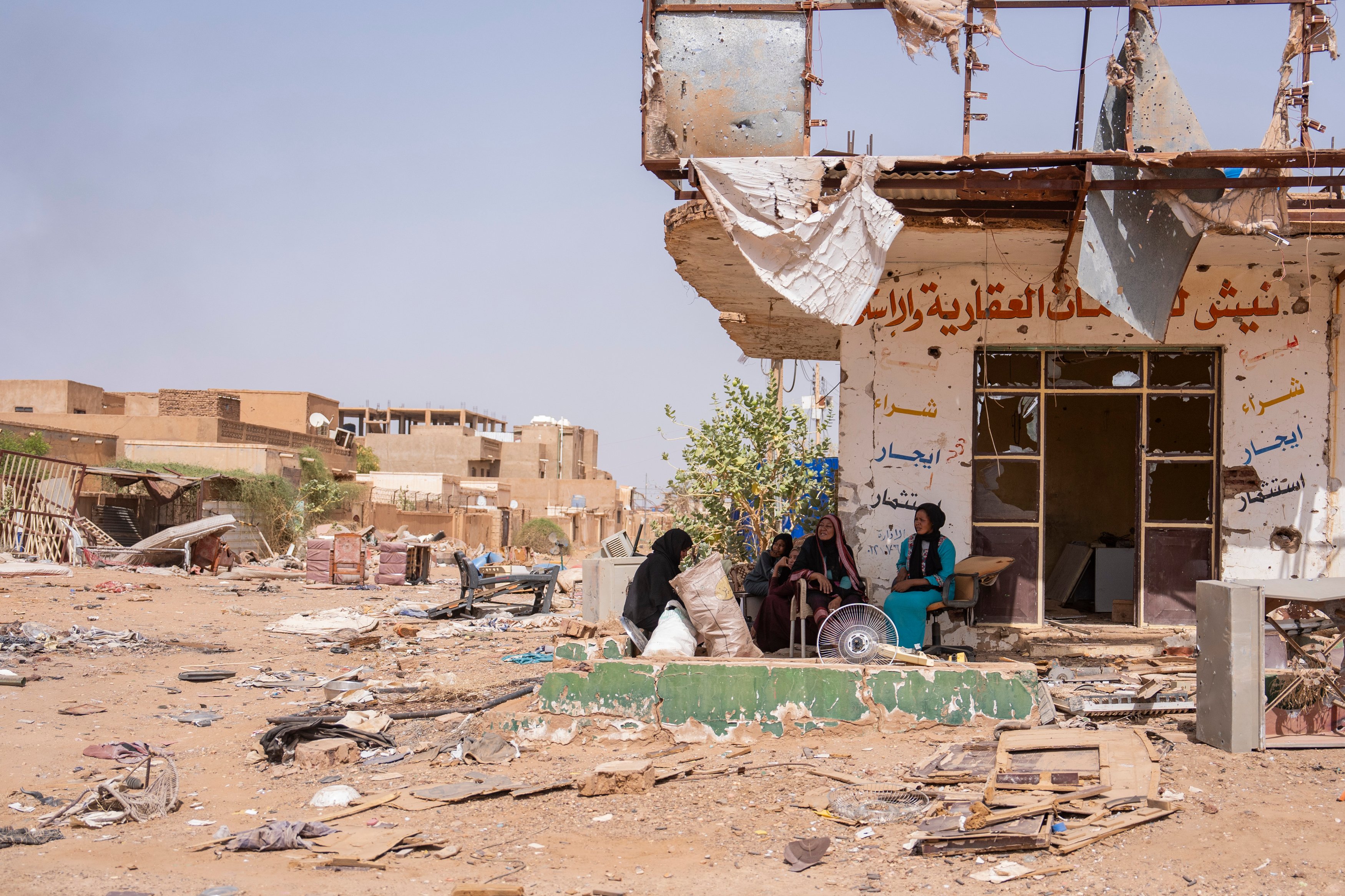 Women sit and talk in a destroyed section of Omdurman.