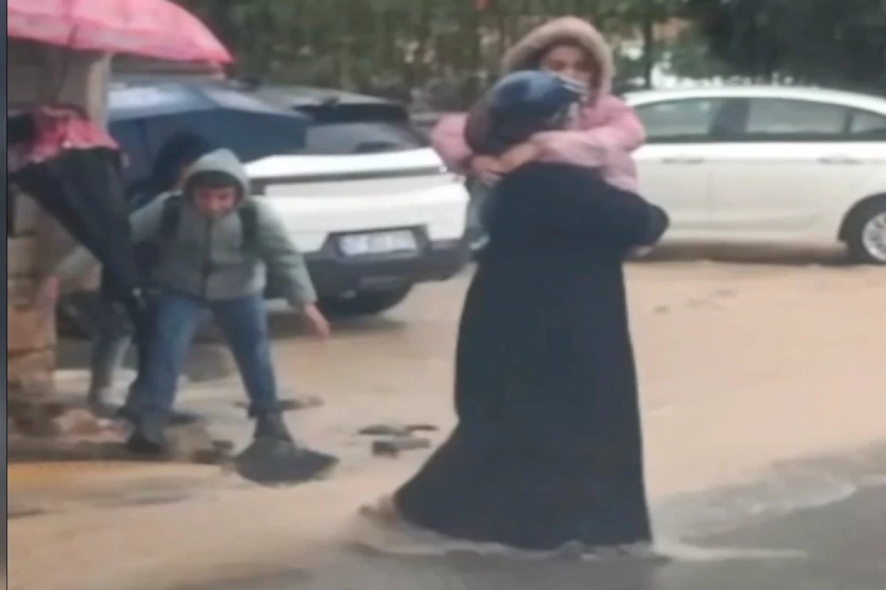 Öğrencileri tek tek kucağında taşıdı